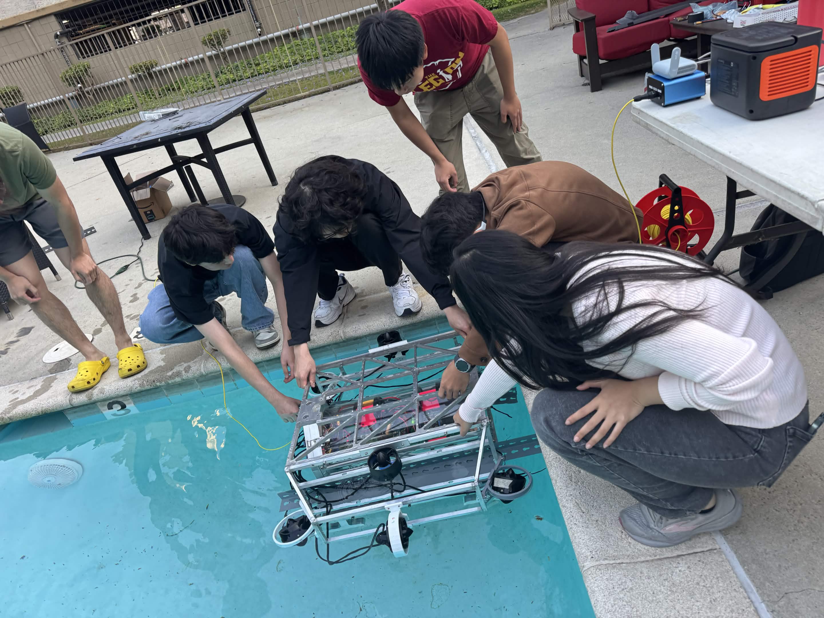 Team members lowering Barracuda into the pool during the May 2, 2026 wet test.