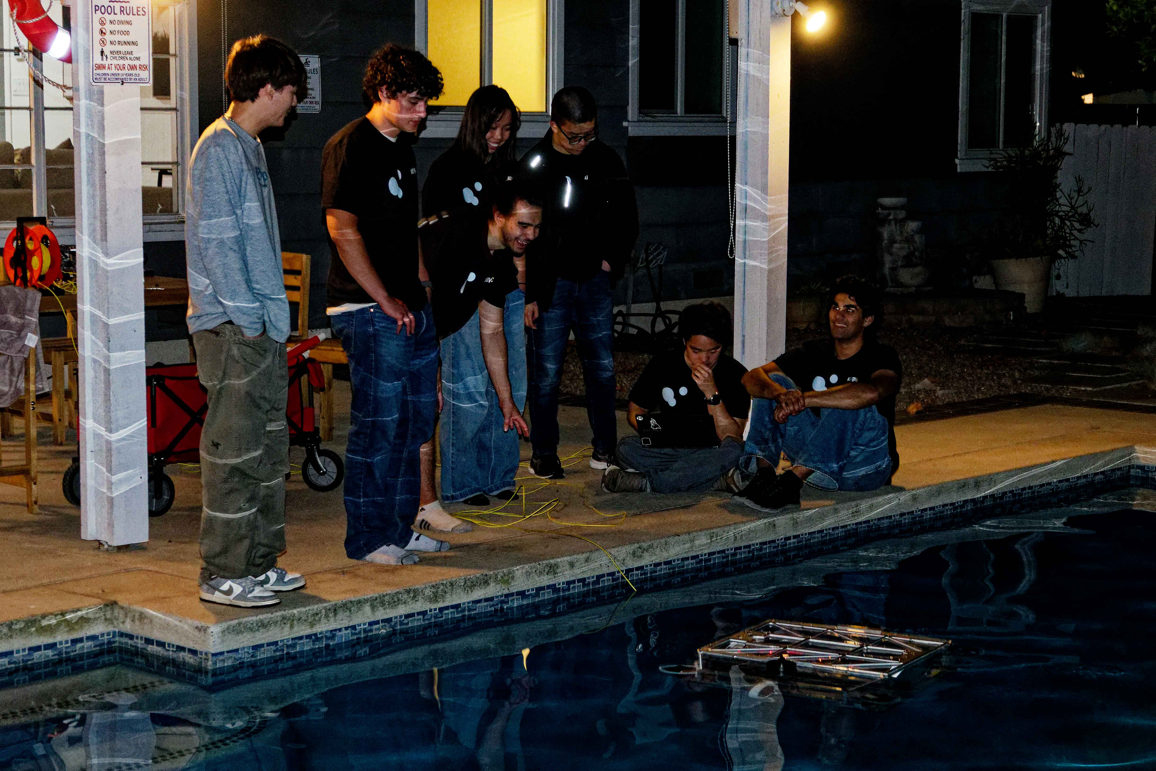 The team gathered around the practice pool at our Airbnb at night, watching Barracuda run during the first day's testing session.